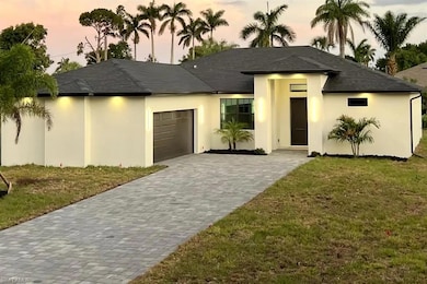 Prairie-style house with stucco siding, a garage, decorative driveway, and a front lawn