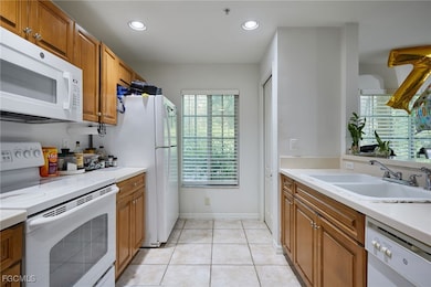 Kitchen with white appliances, brown cabinetry, re