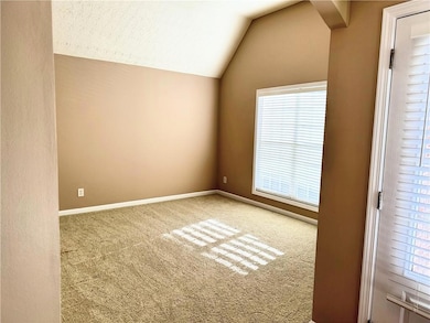 Carpeted empty room with lofted ceiling, baseboard