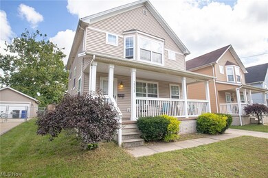 View of front of property with a front yard, garage, and a porch