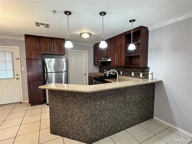 Kitchen with kitchen peninsula, appliances with stainless steel finishes, light tile patterned floors, and backsplash