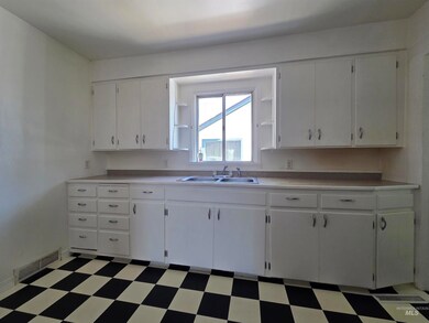 Kitchen with light flooring, white cabinetry, and light countertops