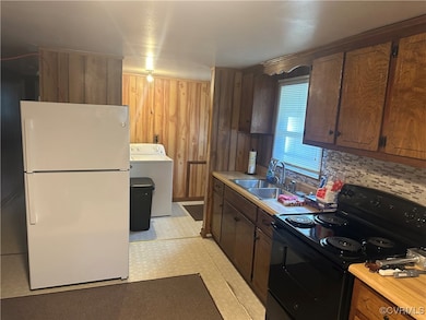 Kitchen with white refrigerator, wood walls, sink,