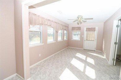 Unfurnished room featuring light colored carpet and a ceiling fan