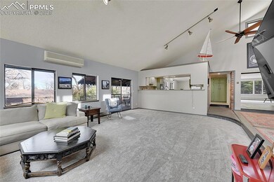 Carpeted living area featuring a wall unit AC, a t