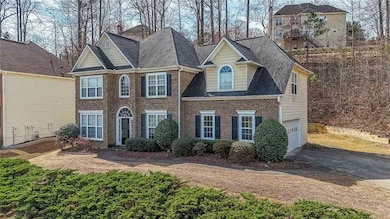 View of front of home with a garage, brick siding,