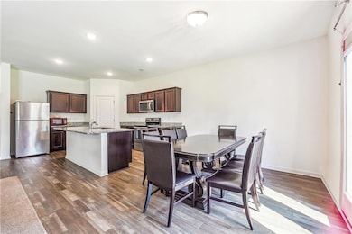 Dining space with dark wood-style floors and recessed lighting