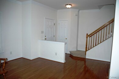 Entry foyer with hardwood floor and coat closet.