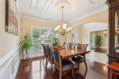 Dining area with crown molding, arched walkways, a