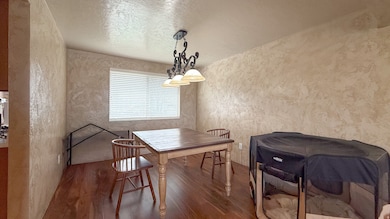 Dining room with wood finished floors, a textured ceiling, and a textured wall