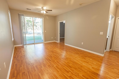 Empty room with light wood-style floors, visible v