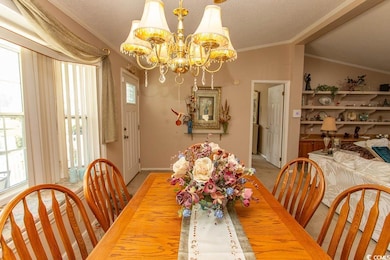 Dining room featuring baseboards, a chandelier, and ornamental molding