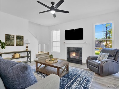 Living room with ceiling fan and light wood-type f