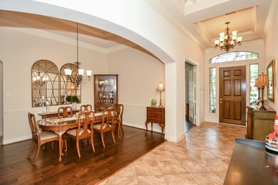 Foyer with nice architectural ceiling has tile flooring. Formal dining room to the left boasts gleaming hardwoods. Arched entry adds a nice touch.