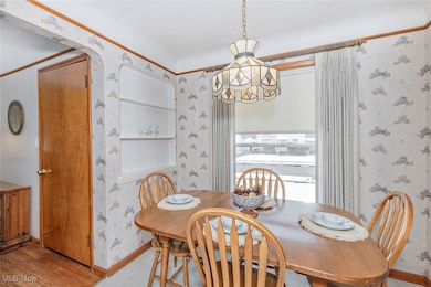 Dining space with wood finished floors, and a chandelier