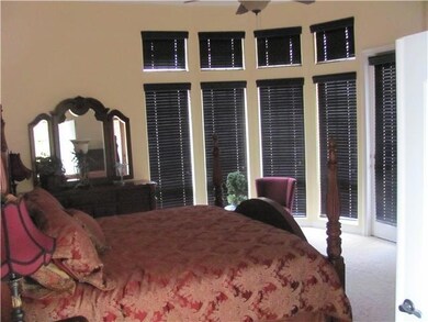 Spacious Master Suite that dreams are made of with curved wall of windows and door thats steps on to the patio.
