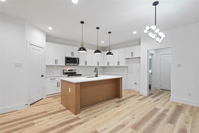 Kitchen with a sink, backsplash, light wood-type f