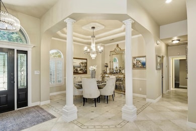 Foyer featuring a raised ceiling, a chandelier, l