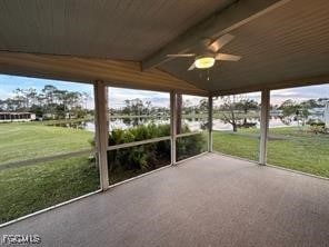 Unfurnished sunroom featuring a ceiling fan