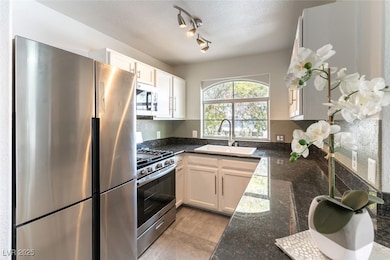 Kitchen featuring a textured ceiling, white cabine