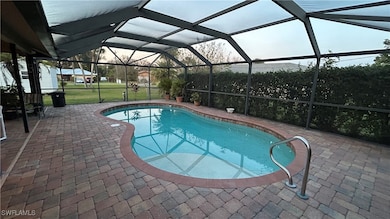 View of swimming pool featuring a lawn, glass encl