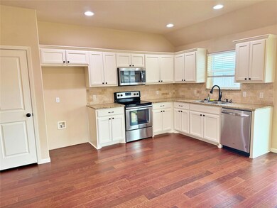 Unfurnished living room featuring ceiling fan, sink, and dark hardwood / wood-style flooring