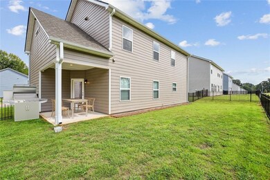 Rear view of house with a patio and a lawn
