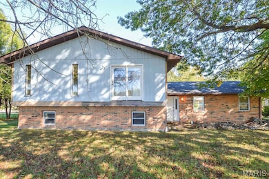View of side of home with brick siding and a lawn