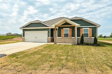 Craftsman-style house with board and batten siding, driveway, an attached garage, and a front yard