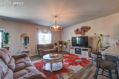 Living room with wood finished floors and a chandelier