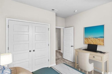 Carpeted bedroom with visible vents, baseboards, a
