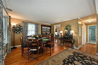 Bright dining spot with hardwood floors and windows overlooking the yard.
