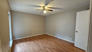 Unfurnished room with a ceiling fan, wood finished floors, and a textured ceiling