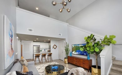 Living room featuring high vaulted ceiling and lig