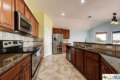 Kitchen features stainless steel and granite count
