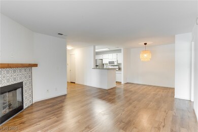 Unfurnished living room with a tile fireplace, lig