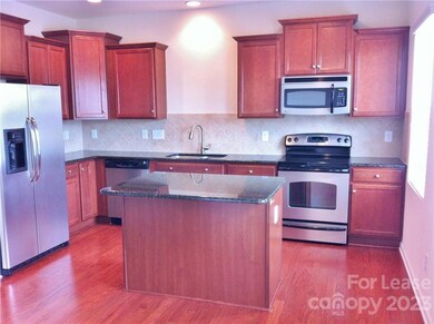 This sweet kitchen offers plenty of cabinet and counter space, even a pantry (not pictured).  Hardwood floors and natural lighting add ambiance. Upgraded features include tile backsplash, granite countertops, castled & stacked cabinetry with lazy susan, stainless appliances, deep stainless sink with high arc faucet/sprayer, recessed lighting and refrigerator with water/ice dispenser.