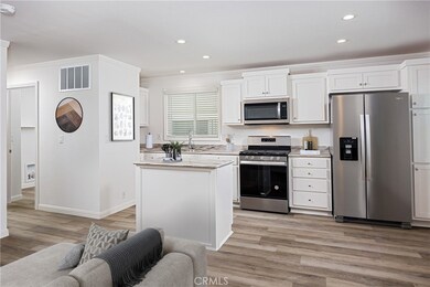 Kitchen has an island and stone countertops (Virtually Staged)