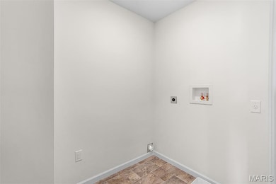 Laundry room with electric dryer hookup, stone finish flooring, and hookup for a washing machine
