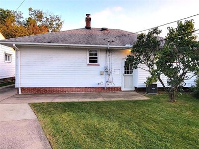 Back of property with a lawn and central AC unit