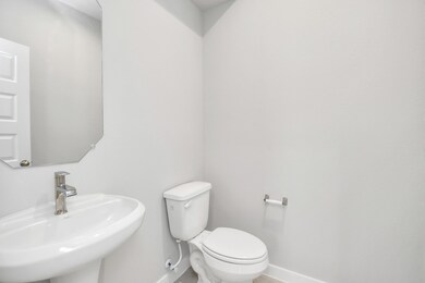 The half bathroom, conveniently situated on the 1st floor, is adorned with contemporary finishes. Custom wall paint, and a sleek faucet combine to create a bright and inviting space. Sample photo of completed home with similar floor plan. Actual colors and selections may vary.
