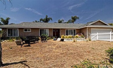 Huge front yard with paved walkway leading to rock
