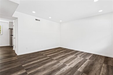 Spare room featuring recessed lighting and dark wood-style flooring