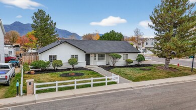 Ranch-style home featuring a fenced front yard, stucco siding, a mountain view, and roof with shingles