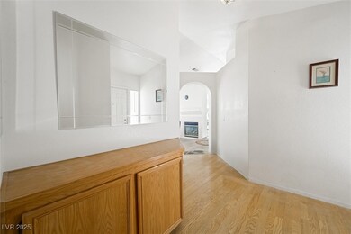 Corridor featuring arched walkways and light wood-