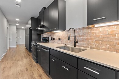 Kitchen with dark cabinetry, stainless steel appl
