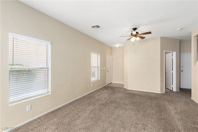 Carpeted spare room with visible vents, baseboards