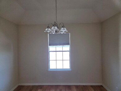 Unfurnished room with dark wood-style floors and a chandelier