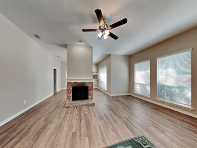 Unfurnished living room featuring wood finished floors, a fireplace, and a ceiling fan