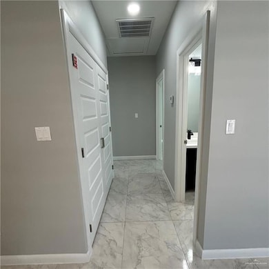 Hallway with baseboards and light marble finish floors